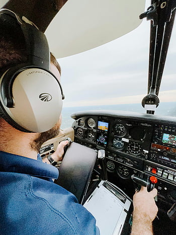 pilot, cockpit, flying plane, small aircraft, headphones, navigating, sunset, flight controls, instrument panel, aviator, aviation
