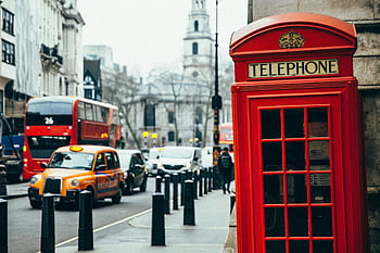 red telephone booth, London street, classic telephone booth, red phone box, London buses, London taxis, bustling street, urban scene, British telephone booth, cityscape, double-decker bus