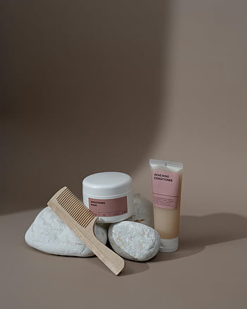 sisir, produk kosmetik, Komposisi minimalis, Produk kecantikan, Estetika yang tenang, masker penghalus, kondisioner pembaruan, sisir kayu, latar belakang batu, nada netral, desain bersih