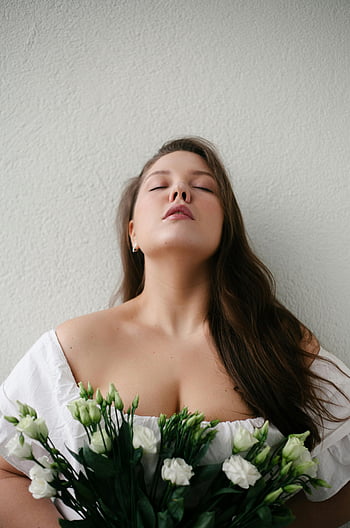 verträumte Frau, geschlossene Augen, Strauß Blumen, Serene Porträt, lange Haare, Zartes Bouquet, weiße Blumen, drinnen, natürliche Schönheit, sanfte Beleuchtung, Friedlicher Ausdruck
