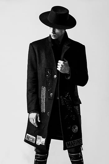 man in black, black hat, black coat, stylish man, wide-brim hat, striking pose, black outfit, fashion photography, monochrome fashion, edgy fashion, menswear style