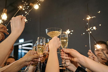tostada de vino, copas de champagne, bengalas, celebración festiva, fiesta interior, adultos celebrando, ocasiones festivas, celebración grupal, tostadas, Ambiente de fiesta, momento de celebración