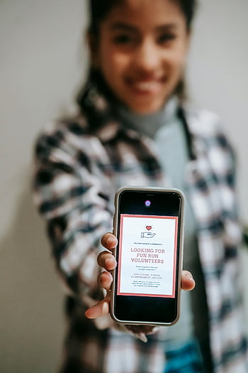 cheerful woman, smartphone, volunteer invitation, positive atmosphere, friendly, fun run volunteers, community event, digital invitation, mobile phone, smiling, volunteer event