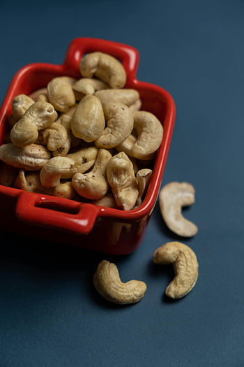 cashew nuts, red container, organic cashews, healthy snacking, close-up, dark background, red bowl, snack, nuts, cashews, container