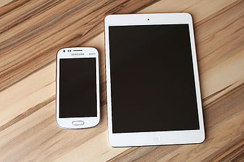 white iPad, Samsung smartphone, wooden table, technology contrast, white smartphone, tablet, digital devices, modern gadgets, tech comparison, electronic devices, tech showcase