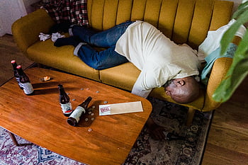 uomo ubriaco, divano letto, bottiglie di orso, tavolo delle monete, fattura in ritardo, stress finanziario, esaurimento, vista dall'alto, bottiglie vuote, divano, lettera