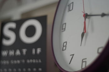 analog wall clock, 6:17, motivational sign, partially visible, background, time display, wall decoration, indoor setting, clock face, hour hand, minute hand