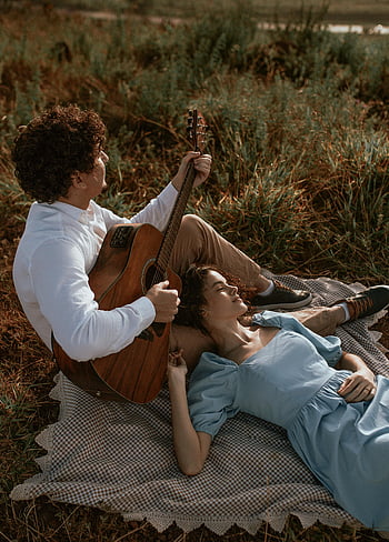 coppia, sdraiato a terra, uomo che suona la chitarra, Momento romantico all'aperto, estate, giovane coppia, coperta da picnic, chitarra acustica, natura, erba, rilassamento