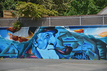 Sztuka uliczna, brodaty mężczyzna, żywe kolory, mur miejski, niebieski pomarańczowy, Tea Man, palenie tytoniu, farba do scian, graffiti, fresk, sztuka plenerowa