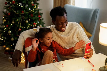 dad and daughter, Christmas, smartphone, laughing, joyous moments, indoor, father and daughter, festive, holiday, family time, memories