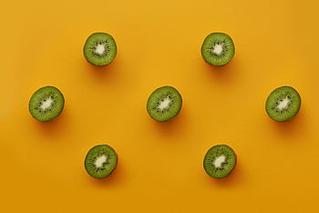 sliced green kiwi fruits, fresh sliced kiwis, vibrant yellow background, healthy food concepts, top view kiwi, kiwi slices, kiwi fruit, healthy eating, fruit photography, kiwi arrangement, yellow background