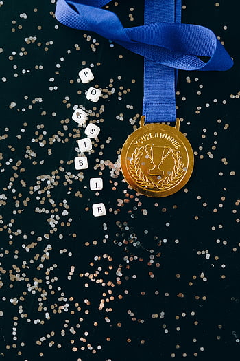 Zlatá medaile, černý povrch, detailní záběr, úspěch, slovo možné, bloků, modrá stužka, konfety, trofej, vítěz, symbolizující