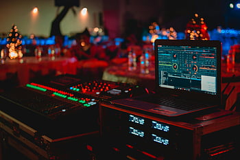 DJ Setup, laptop nero, mixer audio, Evento indoor, evento vivace, Vivid DJ, Attrezzatura DJ, evento musicale, configurazione degli eventi, Tavolo DJ
