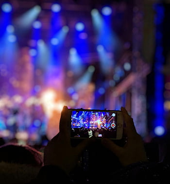 grabación de conciertos, video del teléfono inteligente, luces de concierto vibrantes, manos siluetas, Evento de música en vivo, Iluminación de escenario, grabación de audiencia, fotografía de concierto, grabación móvil, Ambiente de concierto, actuación en vivo