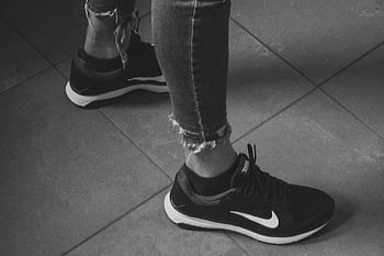 Nike běžecké boty, černé tenisky nike, roztržené džíny, Monochromatický styl, Detailní nohy, ženské nohy, Černý a bílý, neformální móda, pouliční styl, obuv, atletické boty