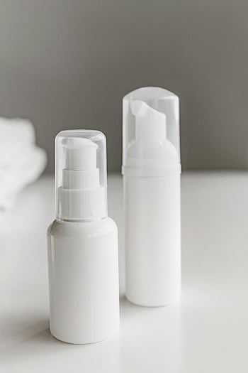 botol plastik putih, permukaan putih, produk perawatan kulit, botol pompa, botol pompa putih, desain minimalis, estetika bersih, Produk kecantikan, wadah putih, latar belakang putih, kemasan perawatan kulit