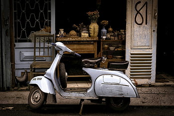 Vespa scooter, white and black, parked, charming café, retro vibes, classic Vespa, motor scooter, building, vintage, street scene, urban setting
