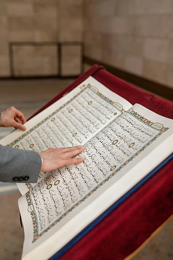 Quran, open Quran, Ramadan, mosque, person reading, Islamic book, religious text, close-up, hands, prayer, holy book