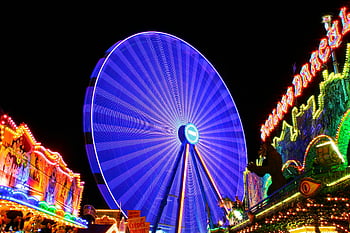 Blue Ferris Wheel, vibrant Ferris wheel, illuminated Ferris wheel, night fairground, lively fairground, colorful lights, amusement park, night scene, carnival ride, fairground attractions, blue lights