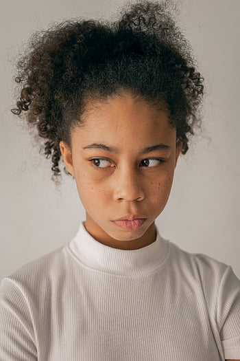Chica negra preocupada, adolescente de pelo rizado, aspecto pensativo, adentro, aislado sobre fondo blanco, cerca de la pared, retrato de niña negra, pelo rizado, expresión pensativa, retrato de interior, Fondo blanco