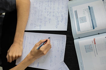 student studying, math equations, solving math, textbooks, papers, desk, diligent student, writing on paper, math problems, study desk, educational materials