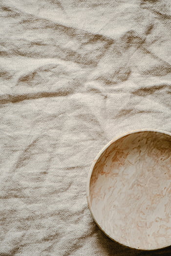 round plate, textile, minimalist ceramic, textured rustic linen, natural aesthetic, plate on fabric, minimalist design, rustic background, ceramic plate, textured background, natural appeal