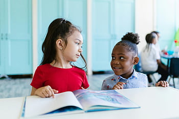 ragazza con camicia rossa, ragazza con la camicia blu, aula, leggere insieme, bambini piccoli, libro, interazione, formazione scolastica, apprendimento, tavolo, sorridente