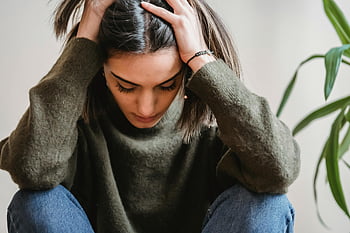 落ち込んだ若い女性、 エスニックレディ、 頭に触れる、 見下ろして、 壁の近くに座っています、 物思いに沈んだ表情、 屋内設定、 若い女性、 頭を持っている、 悲しい気分、 感情的な瞬間