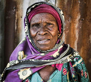 woman, galvanized steel, senior woman, vibrant headscarf, wisdom, resilience, close-up portrait, African woman, traditional attire, outdoor setting, aged beauty