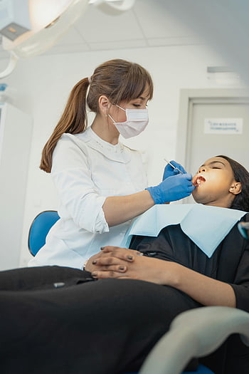 Weiblicher Zahnarzt, zahnärztliche Untersuchung, Zähne des Patienten, Moderne Klinik, Zahnbehandlung, Zahnpflege, Zahnhygiene, Zahnarzt, Zahnarztpraxis, Zahnarztprüfung, Patientenversorgung