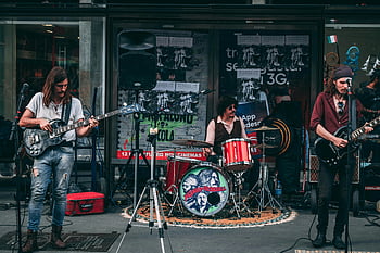 music band, performing live, street performance, indie band, guitarists, drummer, crowd entertainment, building front, live music, street musicians, outdoor concert