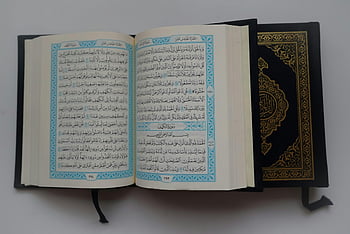 Koran, arabische Schrift, dekorative Abdeckung, Koran offen, Nahansicht, graue Oberfläche, islamisches Buch, heiliges Buch, religiöser Text, Koran Seiten, Arabische Kalligraphie