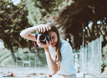 kvinde tager billede, dslr kamera, udendørs indstilling, smilende kvinde, Foto, fotografering, natur baggrund, afslappet tøj, dagtimerne, park scene, oprigtigt øjeblik