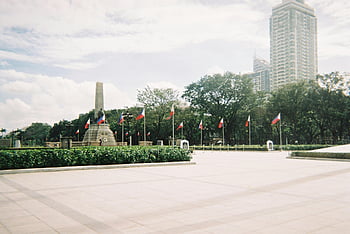 Rizal Park, Rizal Monument, Manila, Philippines, tourist destination, iconic landmark, outdoor scene, Philippine flags, urban park, cityscape, travel destination