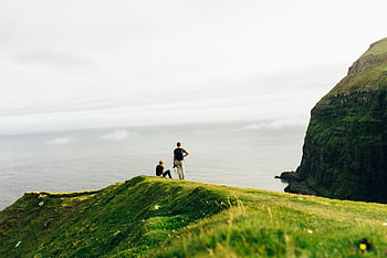 Faroe Islands, seaside, coastal views, lush green cliff, travelers, breathtaking views, nature, outdoor adventure, scenic landscape, travel photography, cliffside scenery