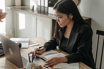 Vrouw die vanuit huis werkt, online lezing, thuiswerkruimte, jonge vrouw, blazer, Notities nemen, laptop, afstandswerk, thuiskantoor, professionele vrouw, gericht werk
