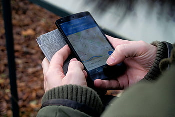 Google Maps, smartphone Android, Navigazione GPS, App mappa, Uso esterno, mani ravvicinate, smartphone nero, app per smartphone, Navigazione all'aperto, persona che usa il telefono, foto ravvicinata
