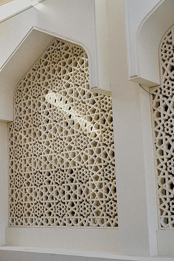 Traditional Islamic window, decorative Islamic window, geometric patterns, mosque wall, Islamic architecture, elegant architectural detail, intricate patterns, Islamic design, mosque decoration, Islamic art, architectural feature