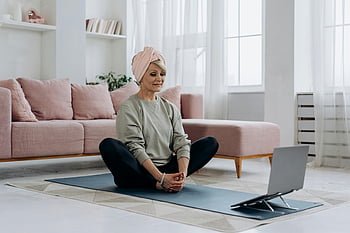 elderly woman, yoga mat, meditating indoors, laptop, exercise, indoor workout, home fitness, senior fitness, yoga practice, home meditation, indoor yoga