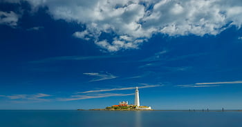 White Lighthouse, St Mary's Lighthouse, dramatic seascape, vibrant blue sky, coastal view, lighthouse photography, ocean scenery, maritime landmark, scenic landscape, island lighthouse, clear sky