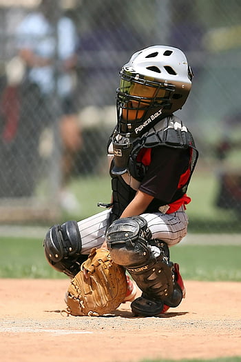 boy, black Power Bolt helmet, baseball catcher, full gear, crouching, field, ready for action, young player, sports equipment, protective gear, baseball game