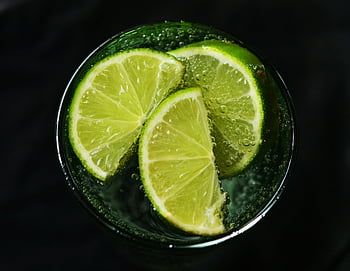 lime slices, drinking glass, sparkling water, fresh lime, close-up, refreshing concept, lime wedges, citrus drink, lime juice, lime water, lime refreshment