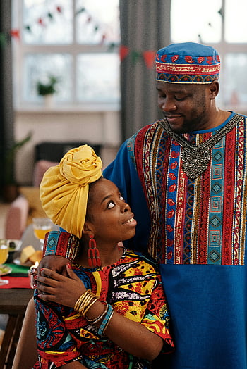 Africký pár, tradiční oděv, Oslava Kwanzaa, Vnitřní oslava, radostný pár, africké kultury, Slavnostní atmosféra, Pár se dívá na sebe, tradiční oblečení, Kulturní oslava, Africký festival