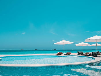 tropische vakantie, Luxe zwembad, uitzicht over de oceaan, duidelijk zwembad, kust, strand uitje, vakantie bestemming, poolparaplu's, Lounge stoelen, tropisch paradijs, Relaxatie aan zee