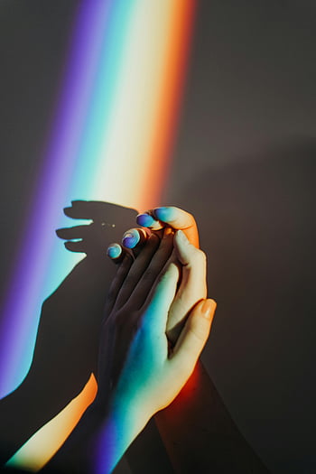 hands with rainbow colors, artistic representation, unity, colorful rainbow light, rainbow reflection, hands holding, shadow, artistic photography, rainbow colors, light reflection, unity concept