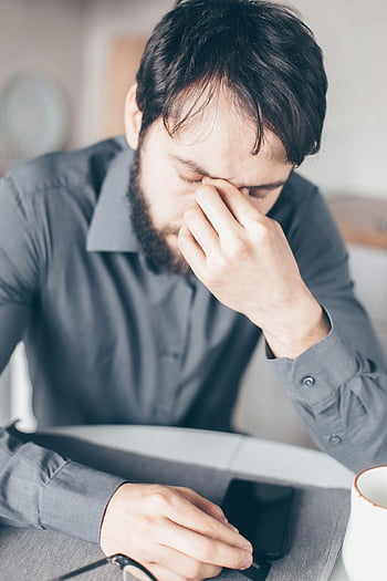 Uomo esausto, camicia grigia, uomo barbuto, stressato, stanco, seduto alla scrivania, lavoro d'ufficio, Affaticamento dell'ufficio, stress da lavoro, Affaticamento mentale