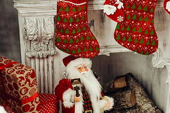 Santa Claus figurine, fireplace, Christmas stockings, cozy Christmas scene, festive stockings, holiday decor, Christmas gifts, Christmas decorations, Santa Claus, Christmas, fireplace mantle