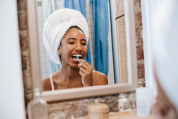 African American woman, flossing teeth, bathroom mirror, daily oral care, routine, black woman, cleaning teeth, flosser, personal hygiene, dental health, towel on head