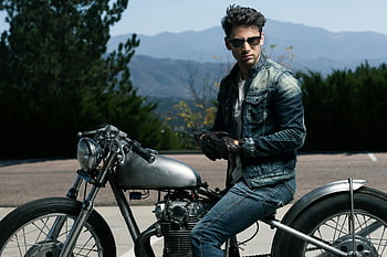 man riding motorcycle, vintage motorcycle, Colorado Springs, mountains background, man on motorcycle, outdoor motorcycle, denim jacket, sunglasses, scenic view, motorcycle rider, classic motorcycle
