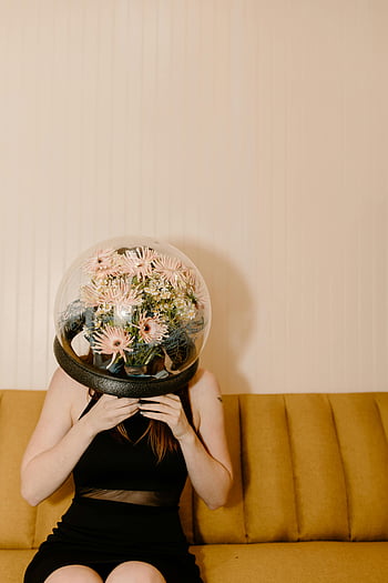 woman, black dress, flower-filled dome, nature, futurism, clear glass ball, artistic photography, creative portrait, modern art, surrealism, indoor setting
